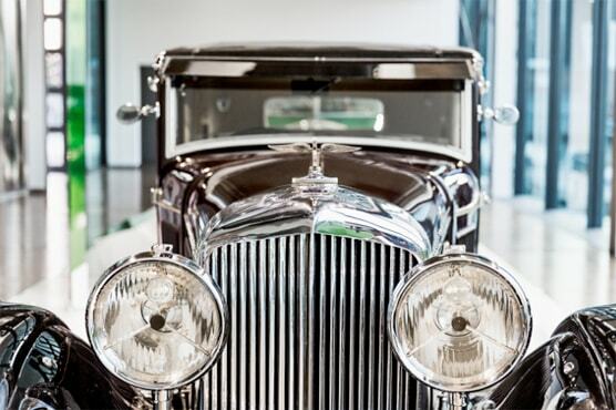Nahaufnahme der Frontlichter eines historischen Bentley im Ausstellungsraum des ZeitHaus.