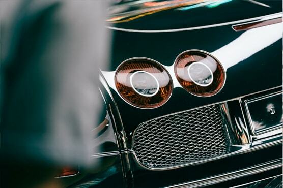 Nahaufnahme eines paares an Frontlichtern eines historischen Bugatti.