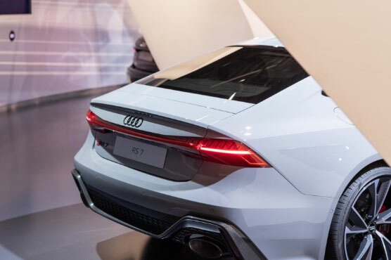 Foto des sportlichen Hecks eines weißen Audi Modells, das in einem Ausstellungsraum steht.