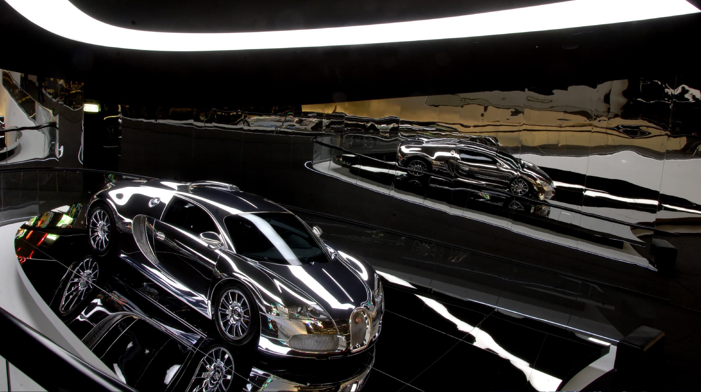 Foto der Spiegelinstallationen im Ausstellungsbereich. Dort steht ein vollständig verspiegelter Bugatti.