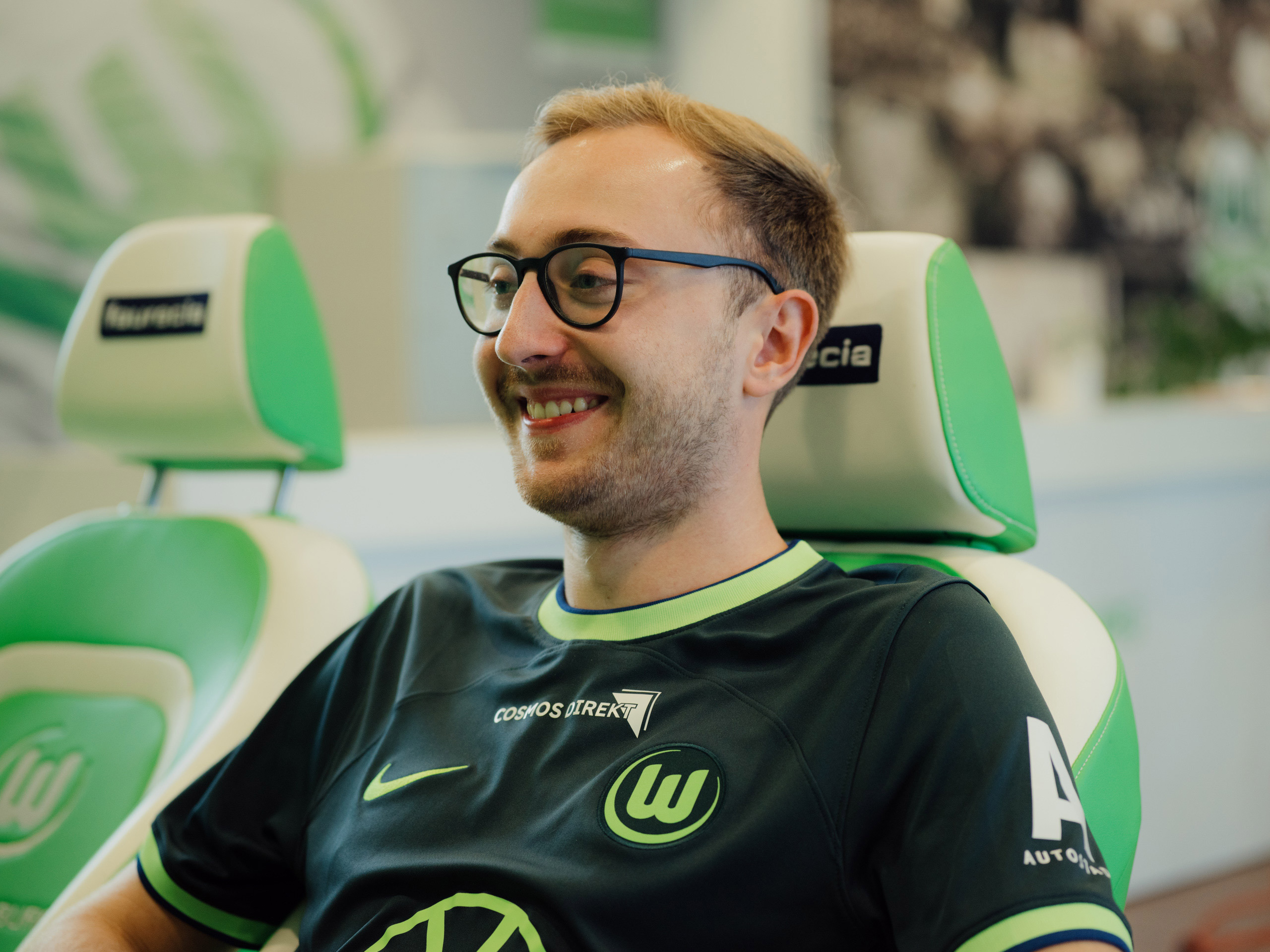 Foto von Max Malle im Profil. Der Gamer sitzt in einem weiß-grünen Stuhl und lacht.